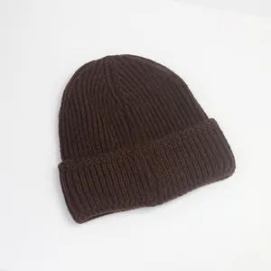 Vue détaillée du bonnet en maille côtelée marron foncé montrant la texture épaisse