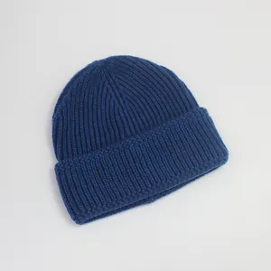 Vue détaillée de la texture tricotée et du revers d'un bonnet en maille bleu foncé