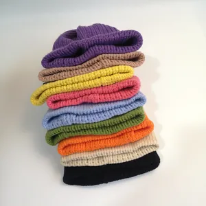 Stack of chunky cable knit beanies in nine vibrant colors on a clean white background