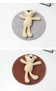 Detailansicht grauer und brauner Wollbarette mit 3D-Teddybär-Dekor aus Lammvlies