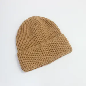 Gros plan sur un bonnet en tricot camel avec texture côtelée et large revers plié