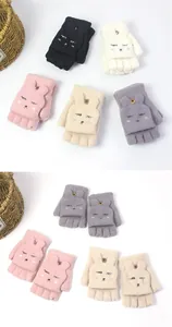 Detail of colorful knitted flip top gloves showing button closure and cute animal embroidery