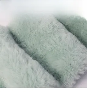 Close-up of soft green faux fur plush fabric texture for children winter scarf