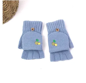 Detail of light blue knitted flip-top gloves with pineapple embroidery and buttons