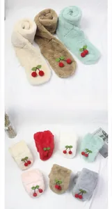 Détail de l'écharpe en peluche pour bébé avec cerise et texture douce pour la peau