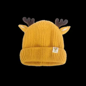 Détail du bonnet tricoté pour bébé avec texture côtelée jaune et bois de cerf marron