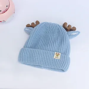 Détail d'un bonnet tricoté pour bébé avec bois marrons et laine bleue côtelée douce