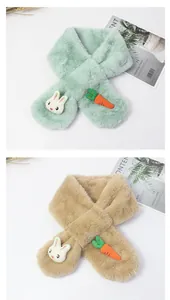 Détail d'une écharpe en peluche pour enfant avec tête de lapin et écusson carotte brodé
