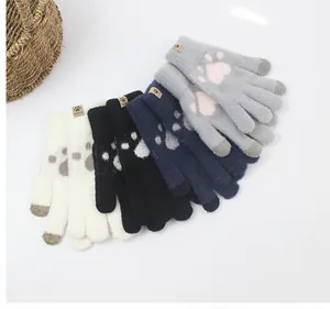 Detailed view of four winter knit gloves with cat paw patterns and touchscreen tips