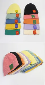 Flach liegende bunte Rippstrick-Beanies für Kinder mit süßen Smiley-Patches