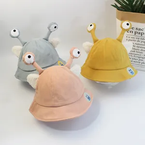 Dettaglio dei cappelli da pescatore per bambini in blu, giallo e rosa con occhi di mostro