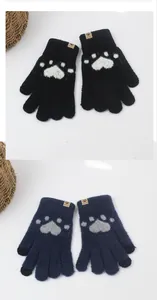 Detail of knitted cat paw gloves with touchscreen tips and brown leather vogue label