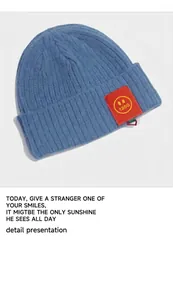 Detailaufnahme der blauen Strickmütze mit rotem Smiley-Patch und dicker Textur für Kinder