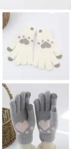 Detail of knitted touchscreen gloves with cat paw patterns and small Vogue label