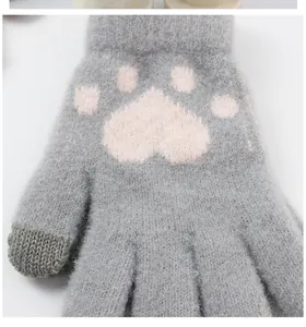 Detail of grey knitted gloves with pink cat paw pattern and touchscreen fingertips
