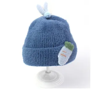 Detailansicht der dunkelblauen Plüsch-Strickmütze für Babys mit süßem Karotten-Dekor