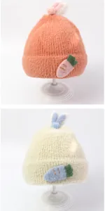 Detailansicht der Plüsch-Baby-Mützen mit Karottenmotiv in Rosa und Beige