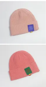 Detailansicht der Rippstrickmützen in Rosa mit bunten 1250 Smiley-Aufnähern