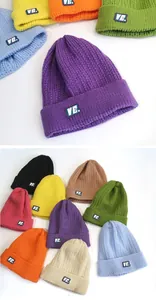Dettaglio ravvicinato della trama del berretto in maglia con opzioni colorate e logo VE