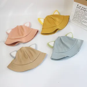 Vue à plat de bobs pour bébés en coton coloré avec de mignonnes oreilles de chat