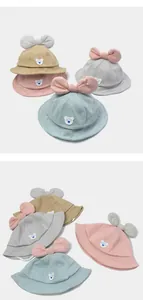 Detailed view of baby sun hats in four colors featuring polka dots and bow decorations