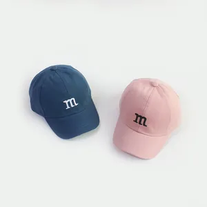 Kinderhonkbalpetten in marineblauw en roze met minimalistisch m-letterborduurwerk