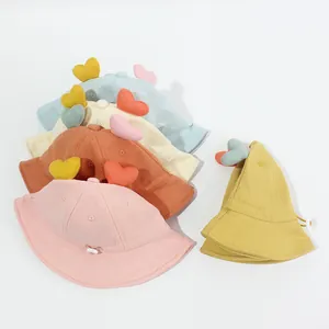 Dettaglio di cappellini da sole in cotone per neonati con cuori 3D e cinturino regolabile