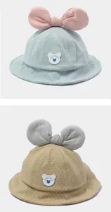 Detail of baby sun hats featuring large bows, polka dot patterns and bear labels