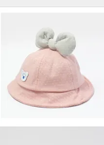 Detail of pink cotton baby sun hat featuring a large grey bow and cute bear patch