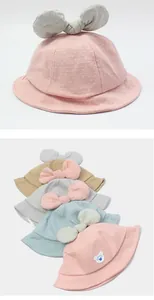 Detail of baby cotton sun hat featuring a large bow and dotted breathable fabric