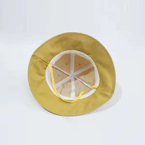 Dettaglio interno del cappello da sole giallo per neonati con fodera e sottogola