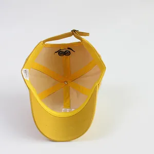 Detail van de gele katoenen kinderpet met mesh voering en oogborduurwerk aan de binnenkant