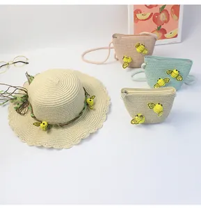 Dettaglio di cappello in paglia a tesa ondulata e mini borse con api 3D applicate