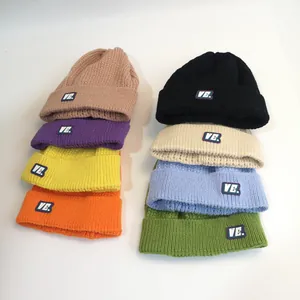 Berretti invernali in maglia a trecce colorati con toppa logo VE per calore e stile