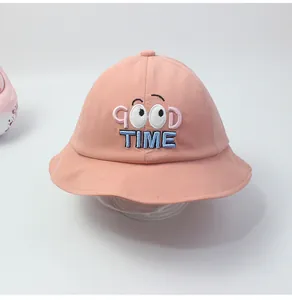 Detail der Stickerei mit GOOD TIME Text und Augen auf dem rosa Baumwoll-Kinderhut