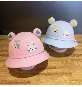 Dettaglio di cappelli da sole rosa e blu per bambini con toppe e orecchie a cuore