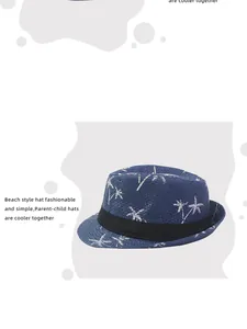 Detail of blue straw fedora with white coconut palm prints and a black decorative ribbon