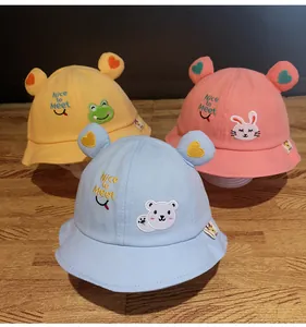 Dettaglio di cappelli da sole per bambini in blu, giallo e rosa con ricami di animali