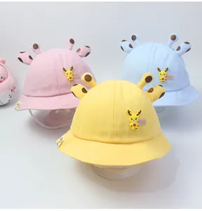 Detalle de tres sombreros de sol de algodón con orejas de jirafa para niños pequeños