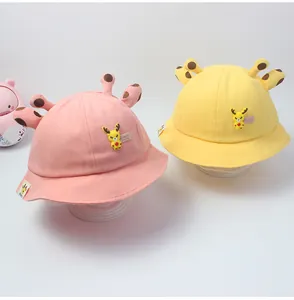 Detalle de sombreros de sol de algodón rosa y amarillo con astas de ciervo 3D y parches