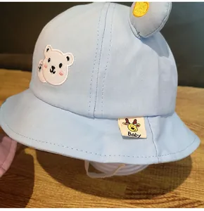 Dettaglio cappello sole neonato azzurro con ricamo orsetto ed etichetta beige baby brand