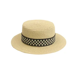 Dettaglio della trama in paglia intrecciata e del nastro a scacchi bianco e nero del cappello