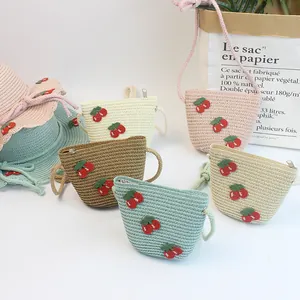 Detail of children's straw hat and crossbody bag set with cute cherry ornaments