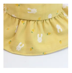 Detail of yellow kids sun hat with rabbit and carrot prints and ruffled brim