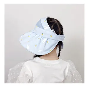 Close-up of girls blue sun hat featuring white rabbit prints and wide wavy brim design