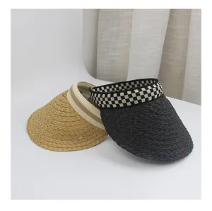 Close-up of raffia sun visors showing natural straw weave and checkered ribbon details