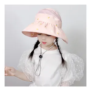 Detailed view of pink sun hat featuring mesh top and cartoon rabbit pattern with chin strap