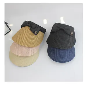 Detail view of woven straw sun hats in multiple colors featuring elegant black bows
