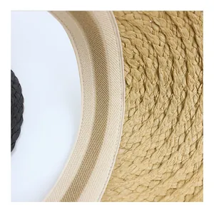 Detailed close-up of straw sun hat weaving with black trim and beige inner sweatband