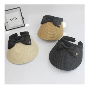 Three colors of straw sun visors featuring large black bows and metallic M logo detail